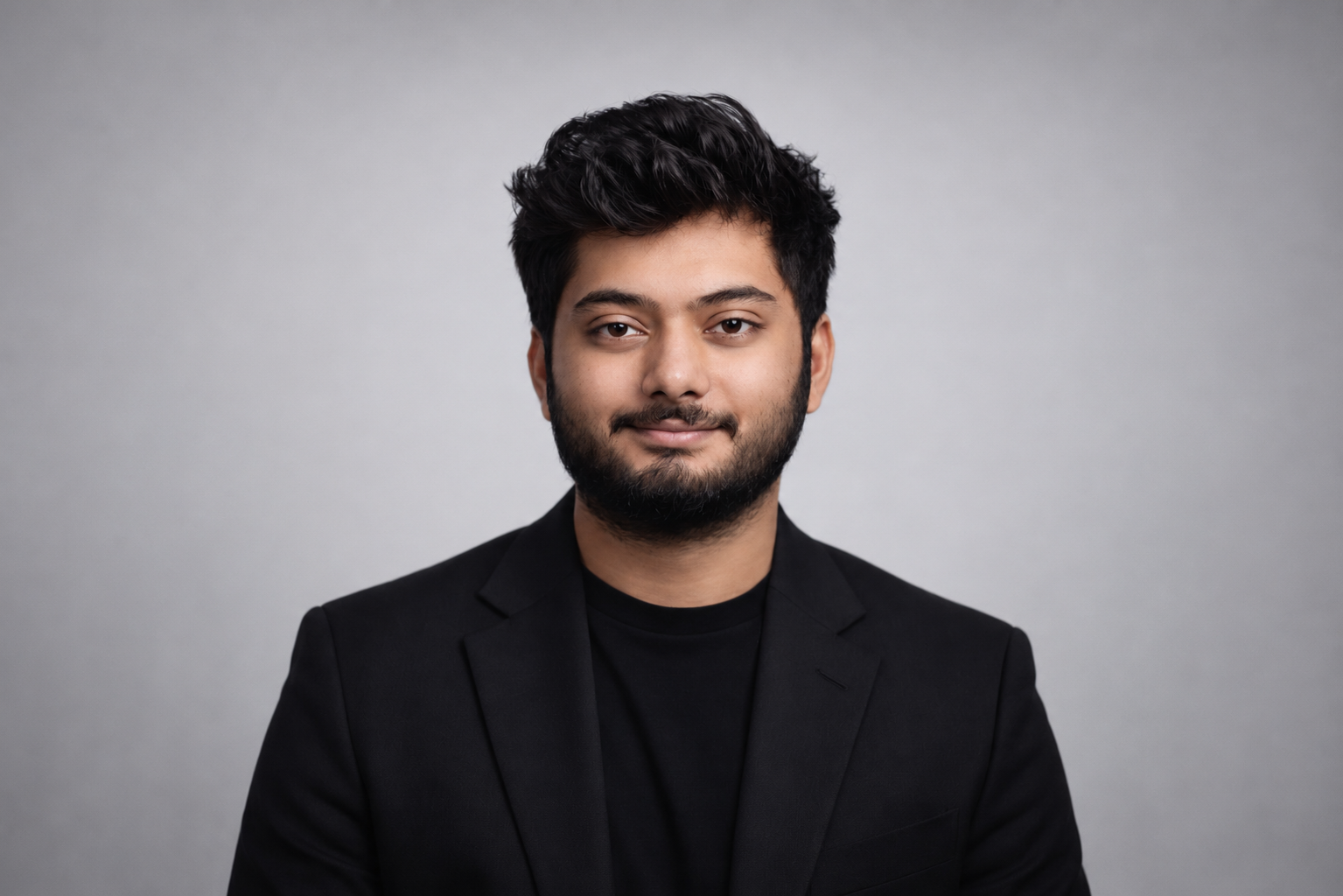 Siddharth Prabhu wearing a black blazer against a gray background